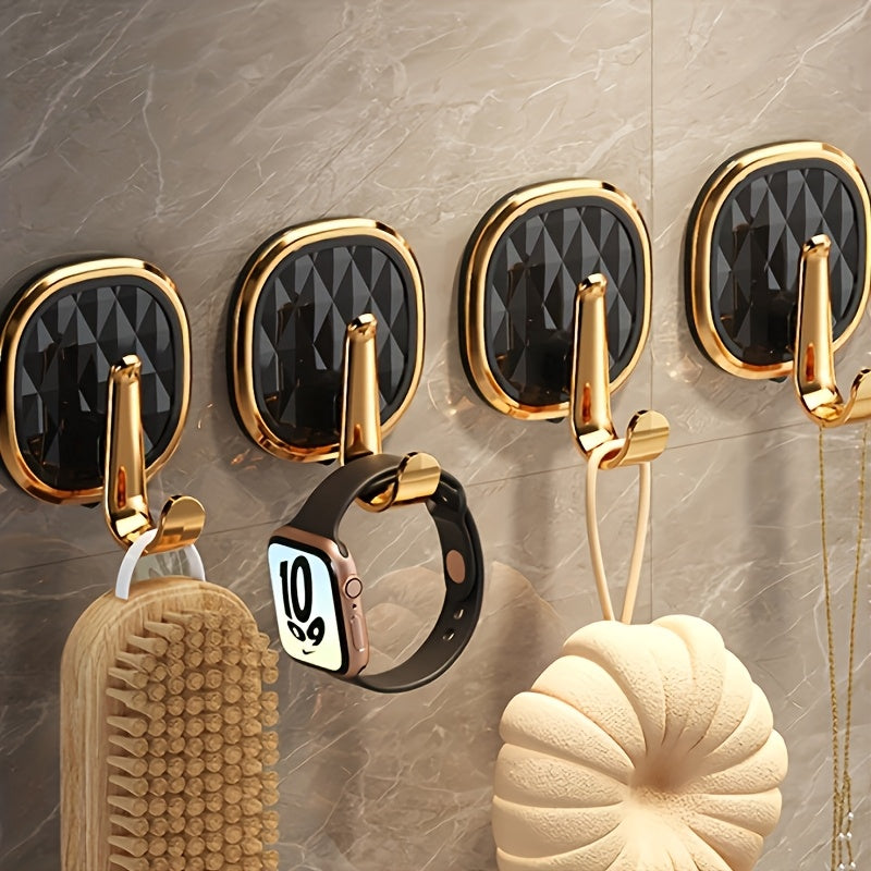 A Stylish Golden Wall-Mounted Hook for Robes And Towels Made of Rust-Resistant Plastic, Featuring a Chic Black Diamond Design. It Has a Strong Adhesive Suitable for Kitchens, Bathrooms, And for Hanging Clothes Or Keys, Utility Hooks
