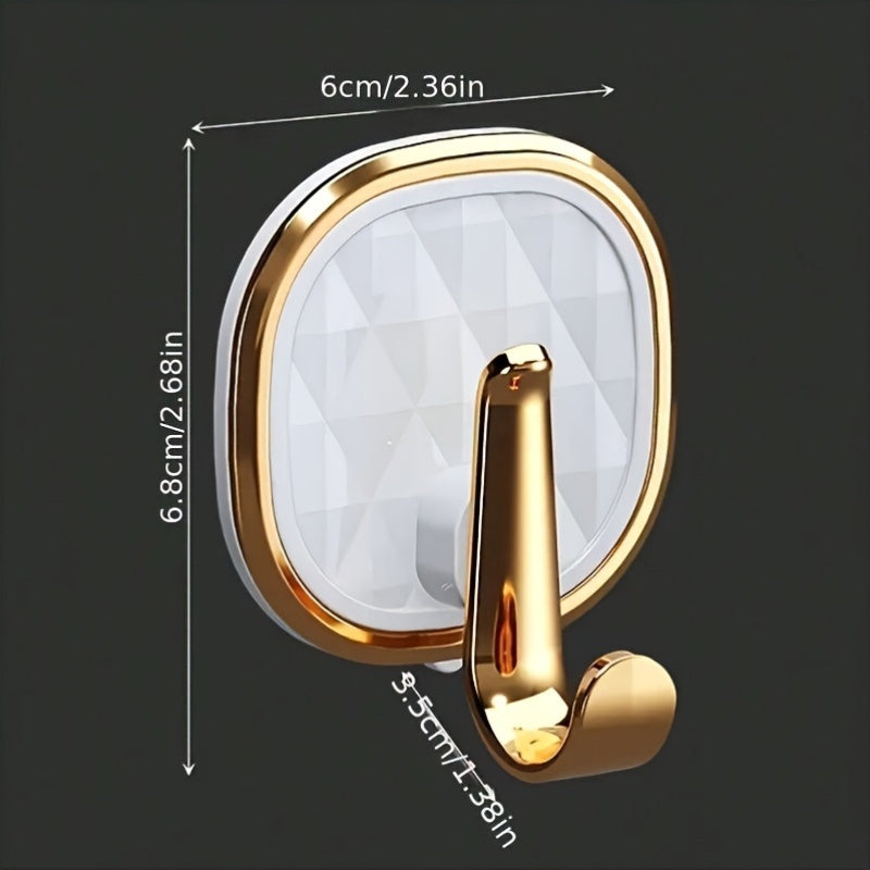 A Stylish Golden Wall-Mounted Hook for Robes And Towels Made of Rust-Resistant Plastic, Featuring a Chic Black Diamond Design. It Has a Strong Adhesive Suitable for Kitchens, Bathrooms, And for Hanging Clothes Or Keys, Utility Hooks